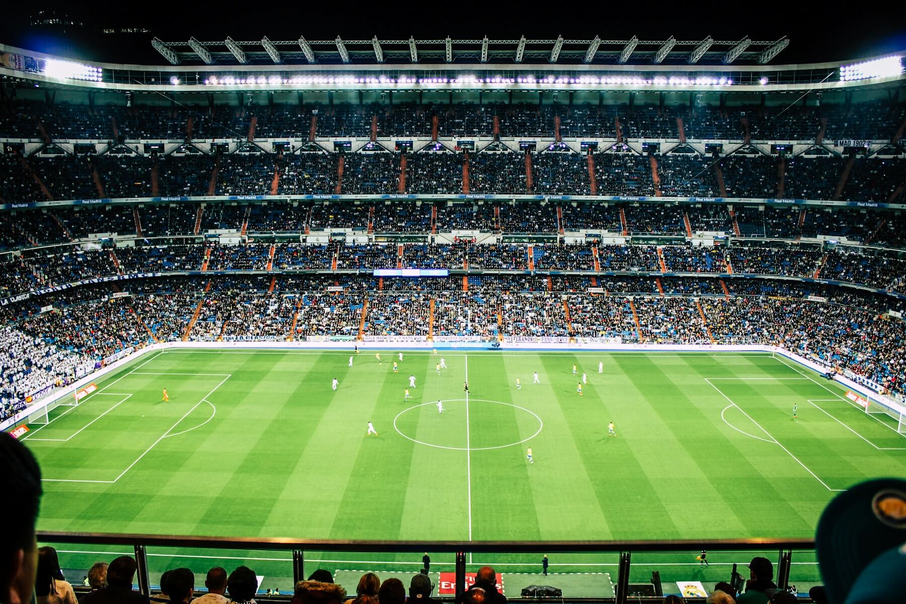 A football stadium and green pitch seen from the stands